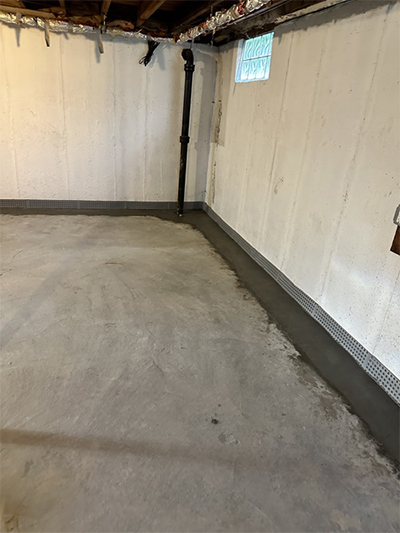 A basement featuring a plain concrete floor and a solid concrete wall