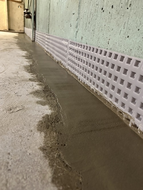 A concrete floor featuring a drain line running across its surface.